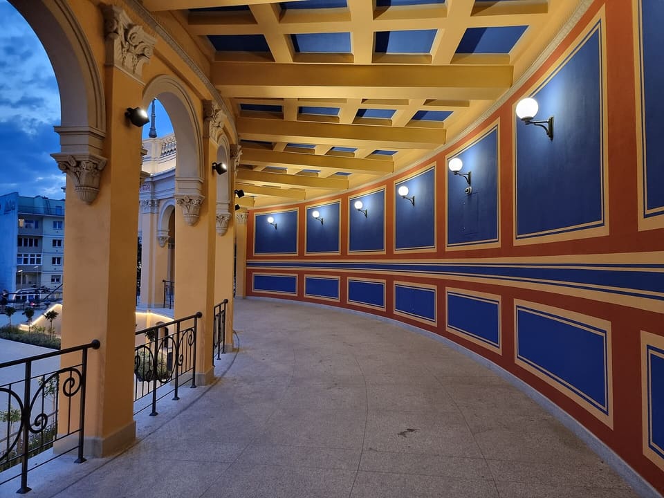 Inside the colonnade of the Bastion Sakwowy: a vaulted walkway with a painted coffered ceiling and blue and red wall panels.