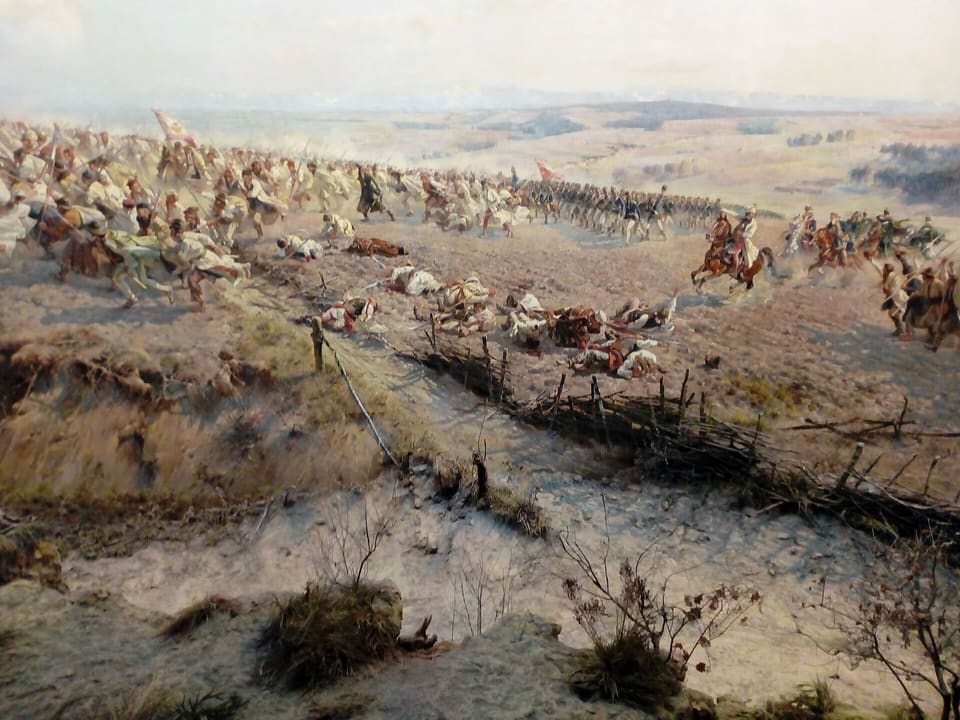 In der Rotunde steigt im Vordergrund ein echter Erdwall mit trockenem Gras und Büschen zum gemalten Schlachtfeld an, wo Aufständische mit Sensen auf Reiterei zustürmen.