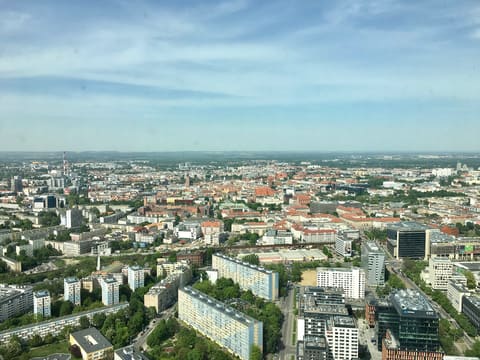 Weiter Blick über Wrocław vom Sky Tower unter blauem Himmel, mit Wohnblocks im Vordergrund.
