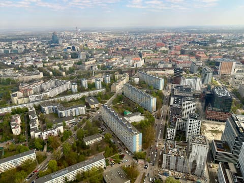 Wrocław vom Sky Tower aus nach Norden gesehen: Wohnblocks und Straßen unten und die Stadt, die sich bis zu einem dunstigen Horizont erstreckt.
