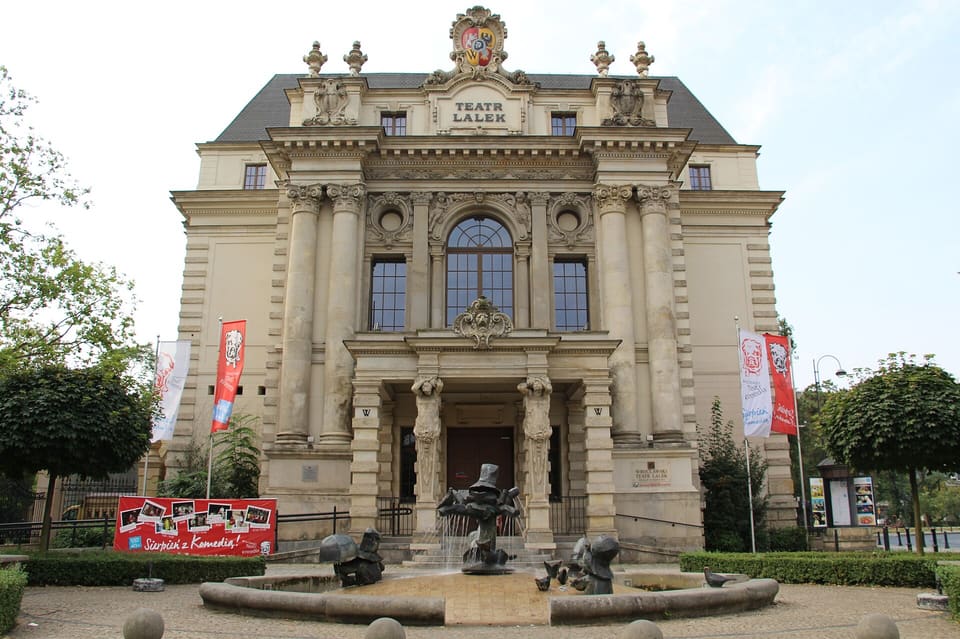 The neo-baroque front of the puppet theatre on Teatralny Square, its columned centre and TEATR LALEK pediment above the small dwarf fountain in the forecourt.
